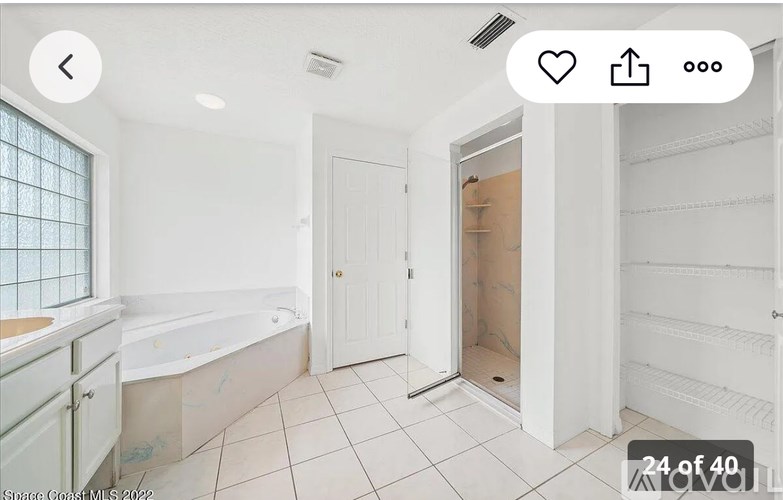 A white bathroom with a bathtub and a door.