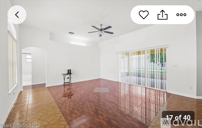 A room with wooden flooring and a ceiling fan.