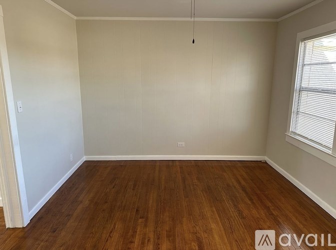 Empty room with wooden flooring and white walls.