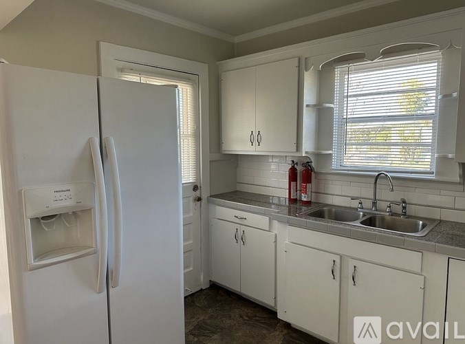 A kitchen with white appliances and cabinets.