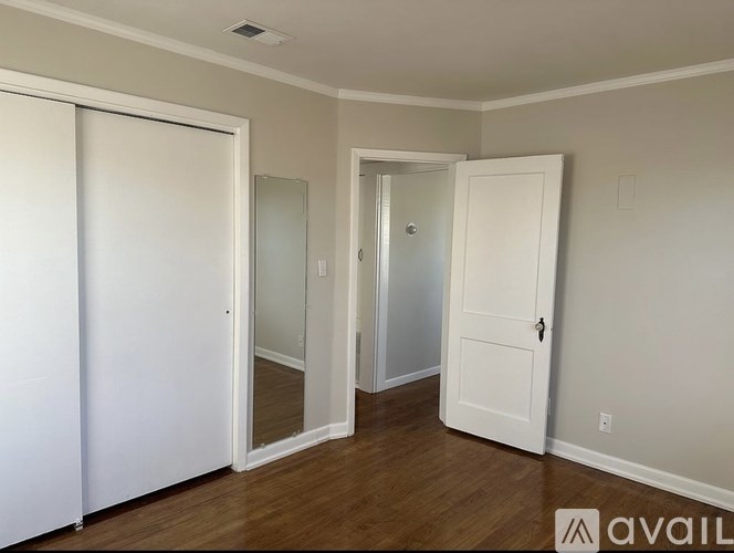 A room with a white door and a mirror on the wall.