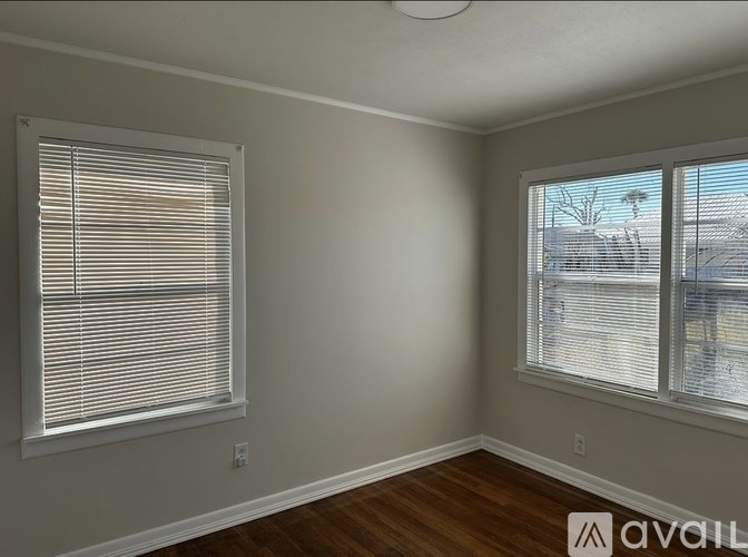 A room with a window and a wooden floor.