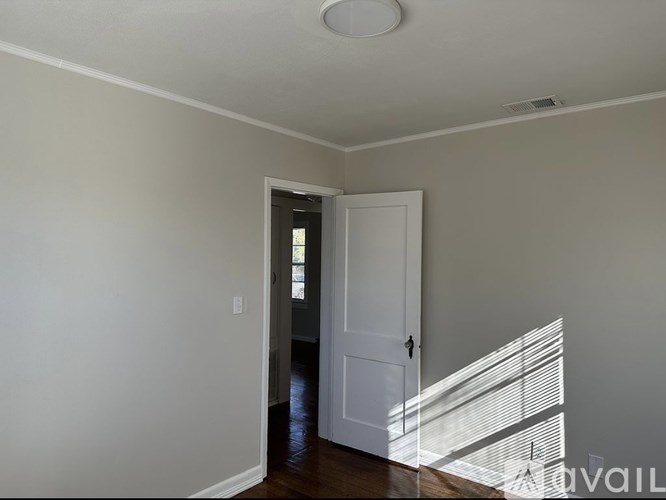 A room with a white door and a window with blinds.