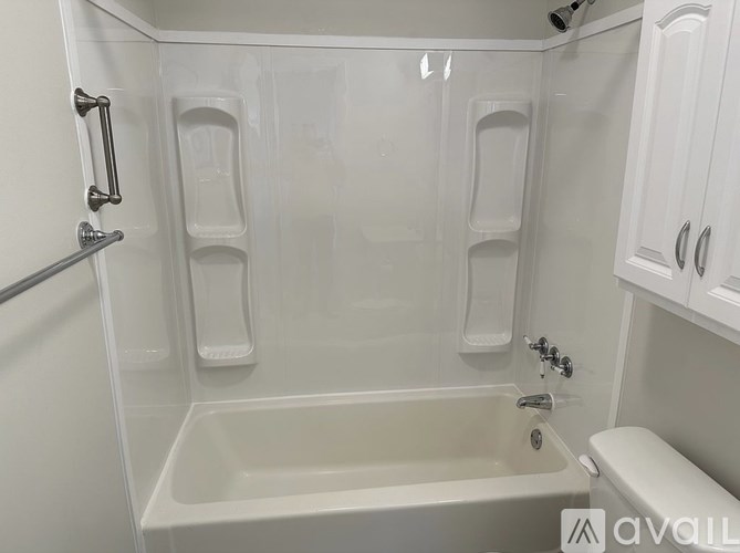 A white bathroom with a tub and toilet.