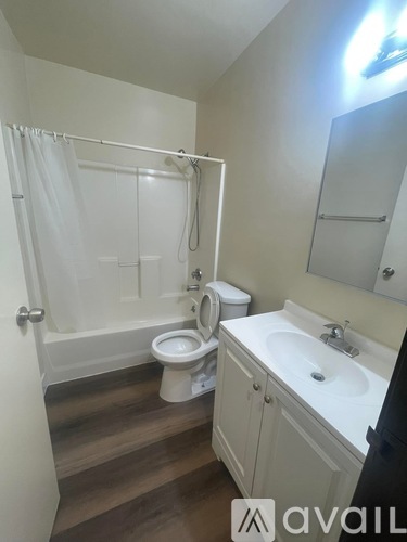 A bathroom with a toilet, sink, and shower.