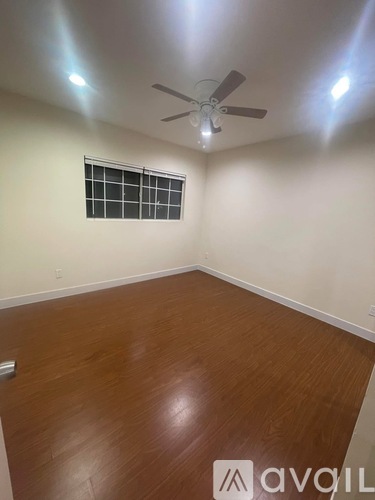 A room with a ceiling fan and wooden flooring.