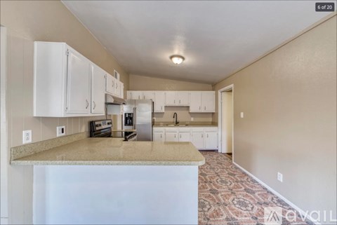 A kitchen with white cabinets and a granite countertop.