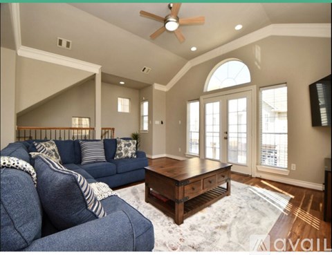 A living room with a blue couch and a wooden coffee table.