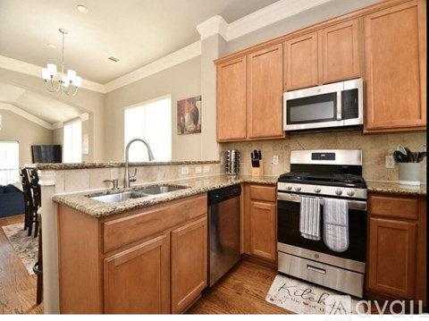 A kitchen with wooden cabinets and a granite countertop.