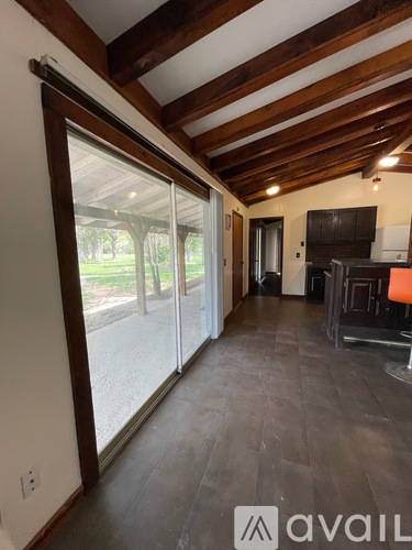 A living room with a sliding glass door leading to a backyard.