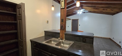 A kitchen with a sink and a wooden beam on the wall.