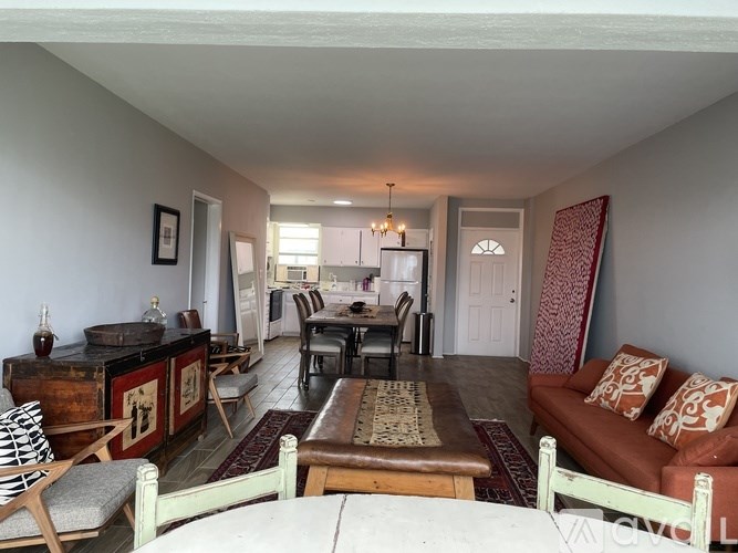 A living room with a couch, chairs, and a coffee table.