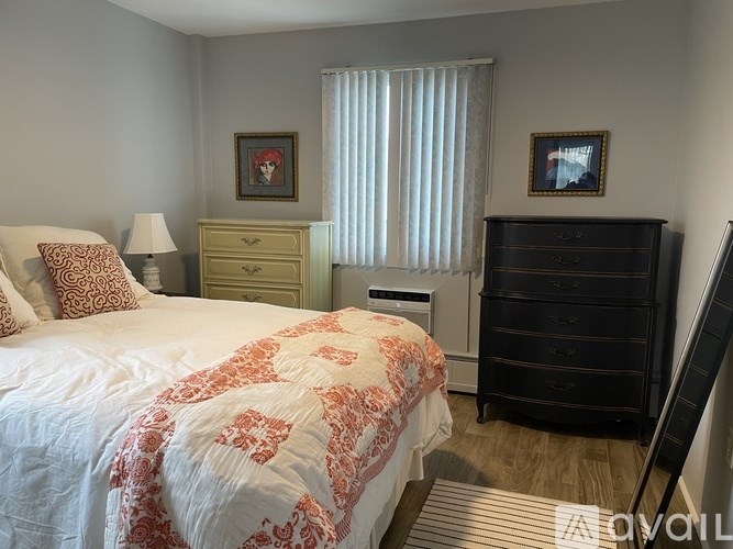 A bedroom with a bed, dresser, and nightstand.