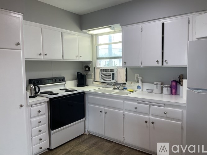 A kitchen with white cabinets and appliances.