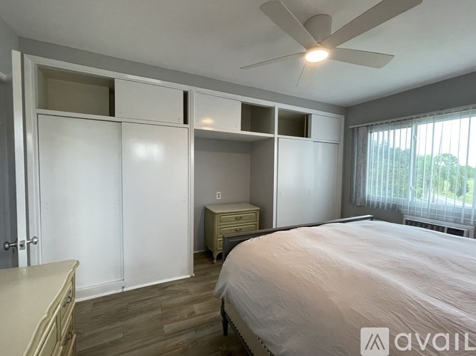 A bedroom with a bed, dresser, and wardrobe.