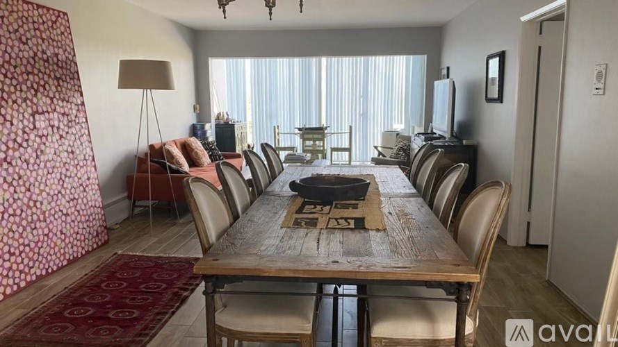A dining room with a long wooden table and chairs.
