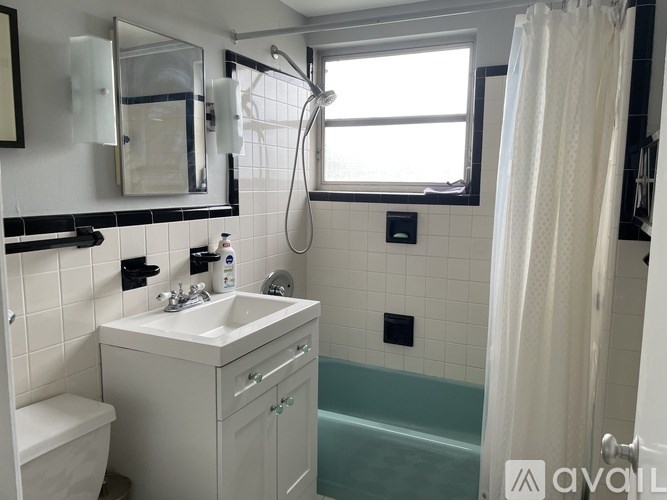 A bathroom with a white sink and a white toilet.