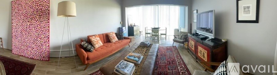 A living room with a red couch and a rug.