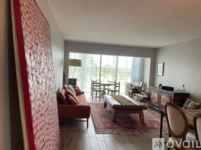 A living room with a red couch and a wooden coffee table.