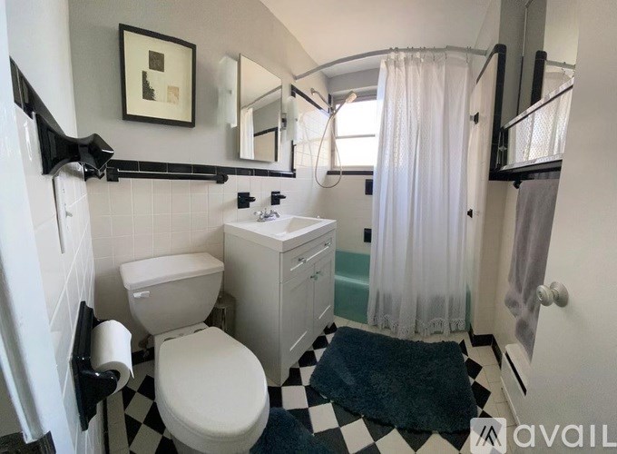 A bathroom with a toilet, sink, and shower.