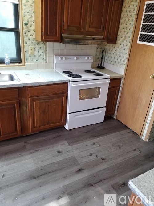 A kitchen with a white stove and wooden cabinets.