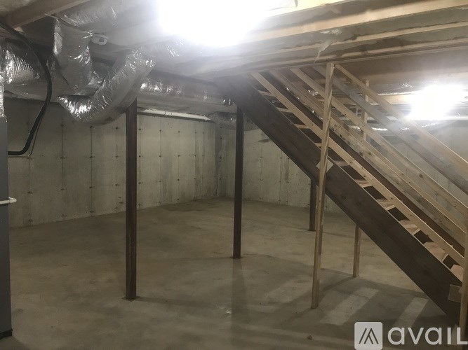 A room with a staircase and ductwork.