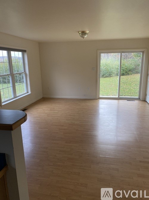 A room with wooden flooring and a sliding glass door.