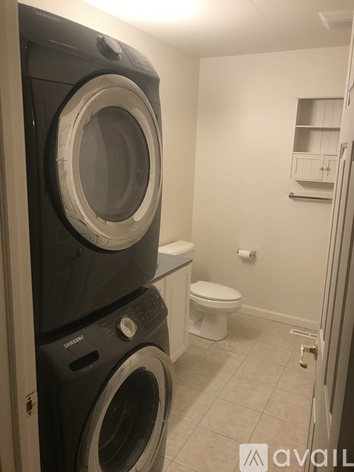 A black washer and dryer in a small laundry room.