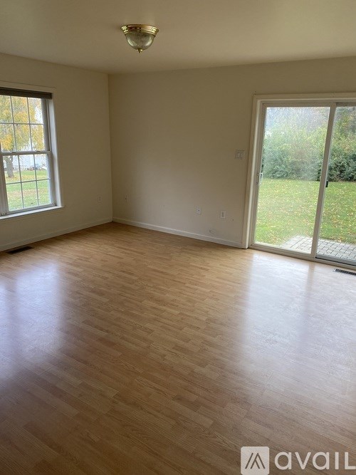 A room with wooden flooring and a sliding glass door.