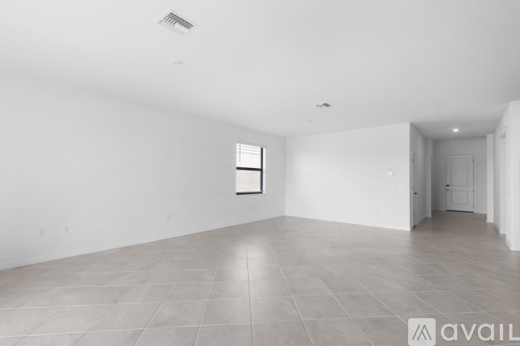 A spacious room with tiled flooring and white walls.