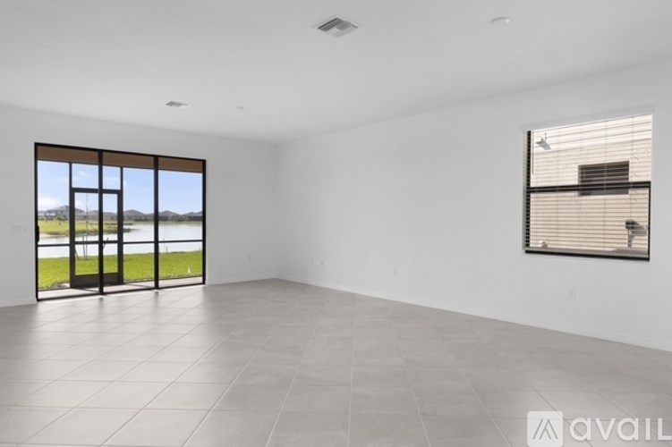A spacious room with a large window overlooking a green landscape.