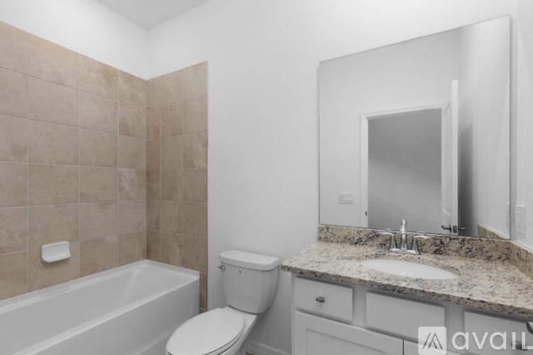 A bathroom with a tub, toilet, and sink.