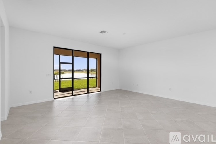 A spacious room with a large window and tiled floor.