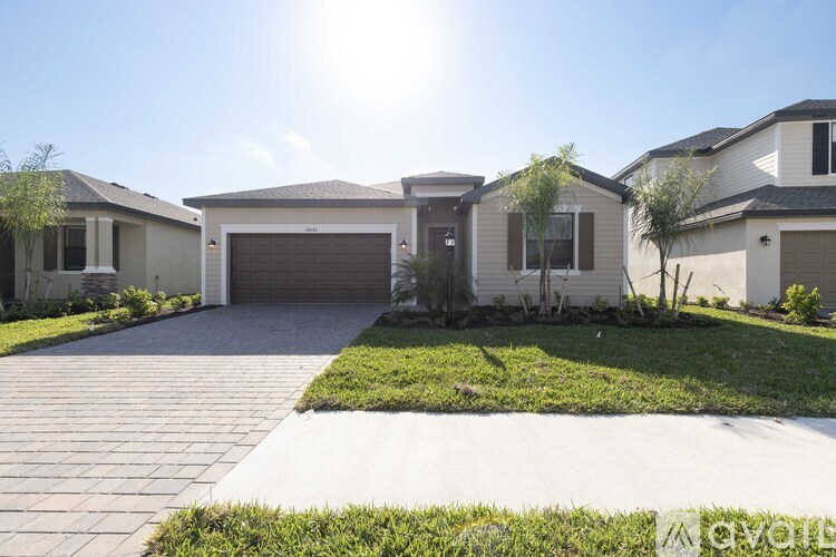 A sunny day in a residential area with houses and a driveway.