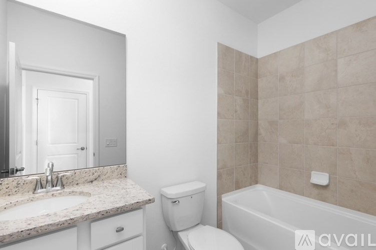 A bathroom with a sink, toilet, and bathtub.