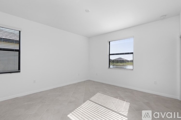 A room with a window and a picture on the wall.