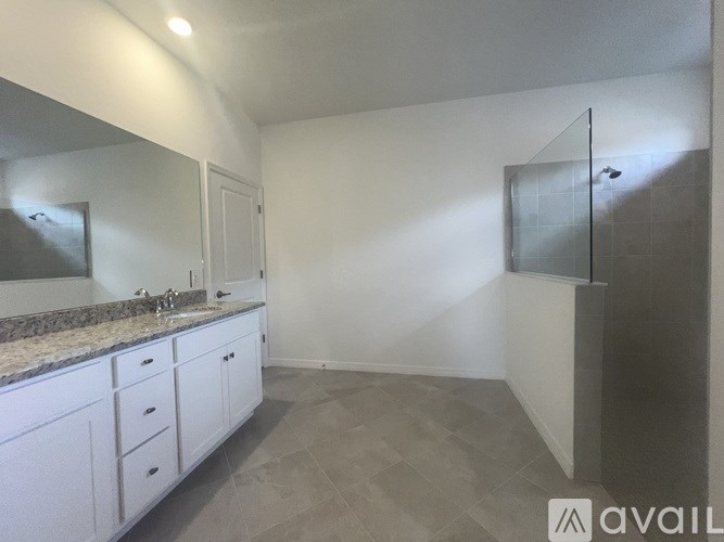 A bathroom with a marble countertop and a walk-in shower.