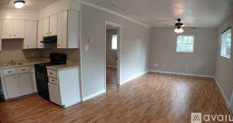 A kitchen with white cabinets and a black stove top oven.