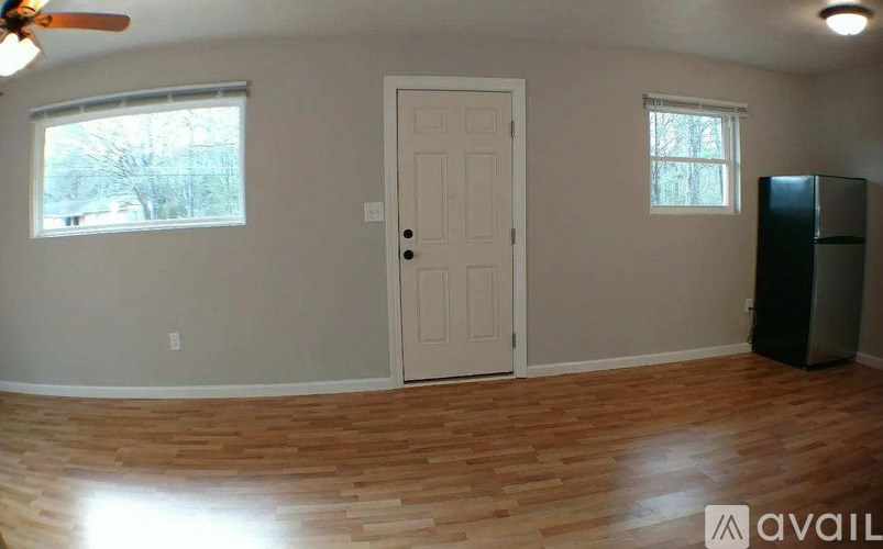 A room with a white door, a window, and a ceiling fan.