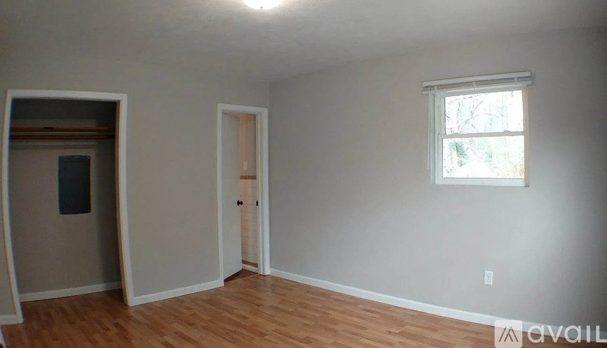 A room with a window and a door is available for rent.