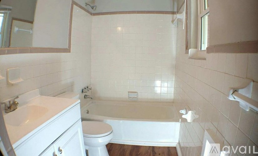 A white bathroom with a tub, toilet and sink.