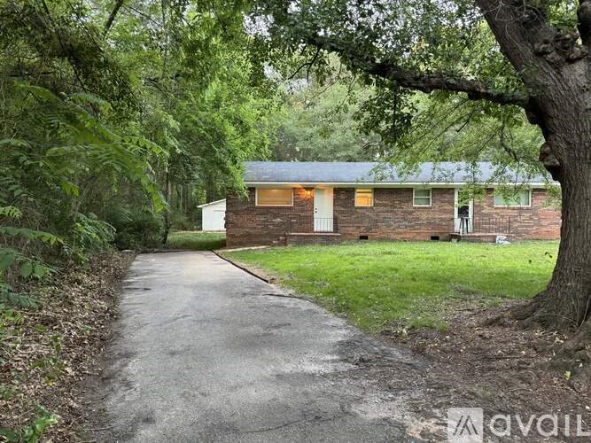 A house with a driveway surrounded by trees.