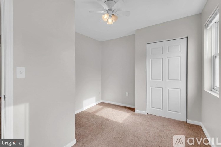 A room with a ceiling fan and a door.