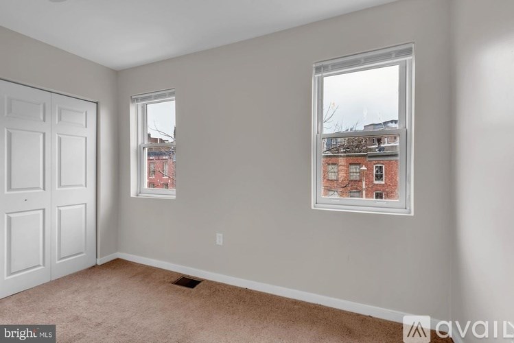 A room with a door and a window showing a view of a building outside.