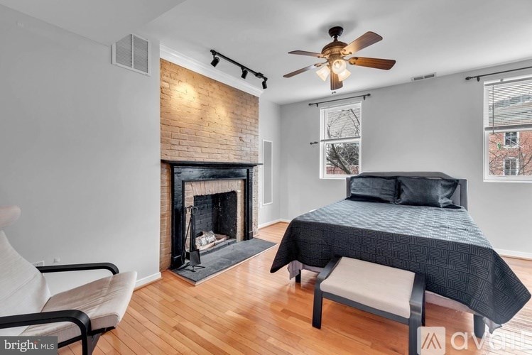 A bedroom with a fireplace and a bed.