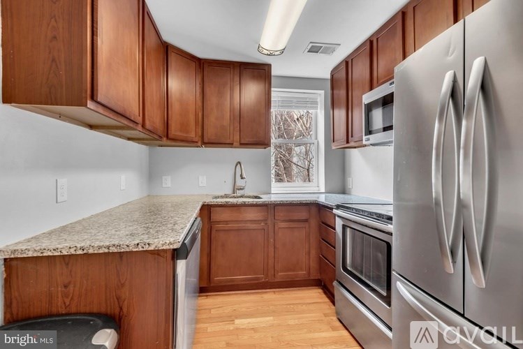 A kitchen with wooden cabinets and a granite countertop.