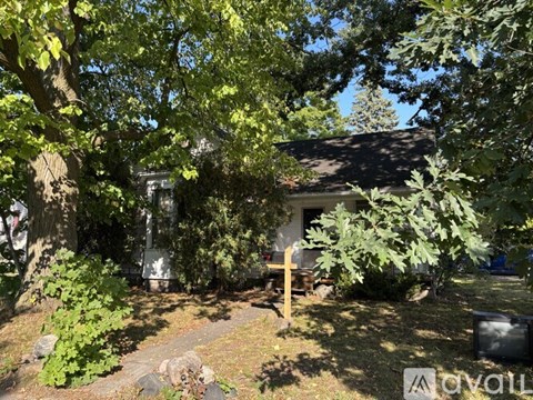 A house is surrounded by trees and bushes.