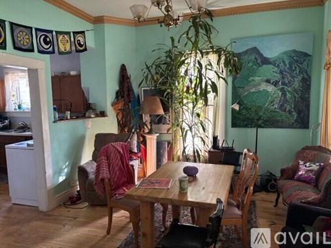 A dining room with a wooden table surrounded by chairs.