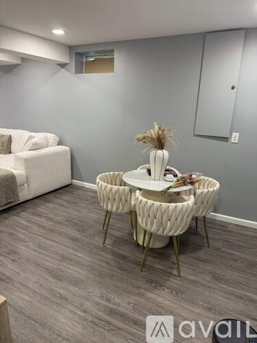 A living room with a white sofa and a table with chairs.