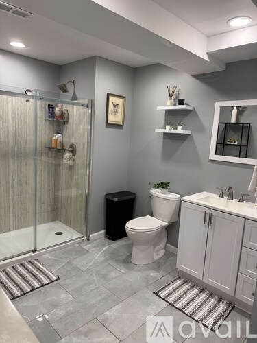 A bathroom with a toilet, sink, and shower.